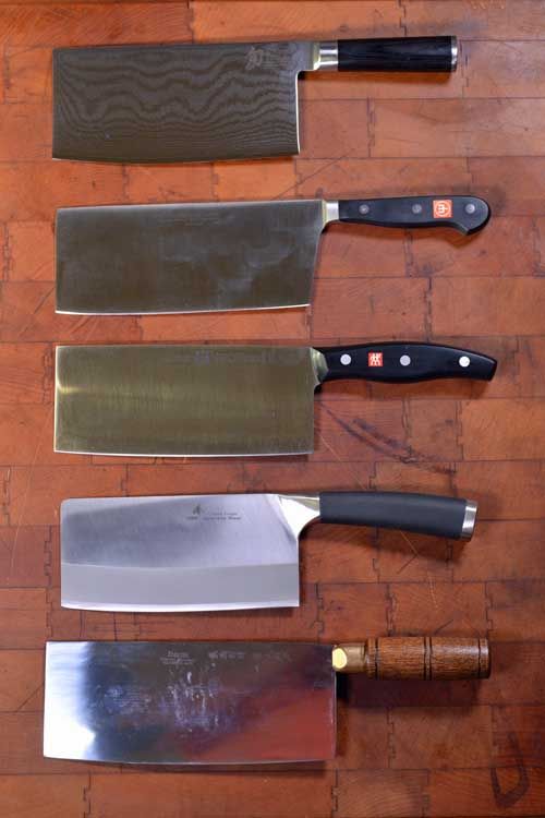 several different types of knives on a wooden table