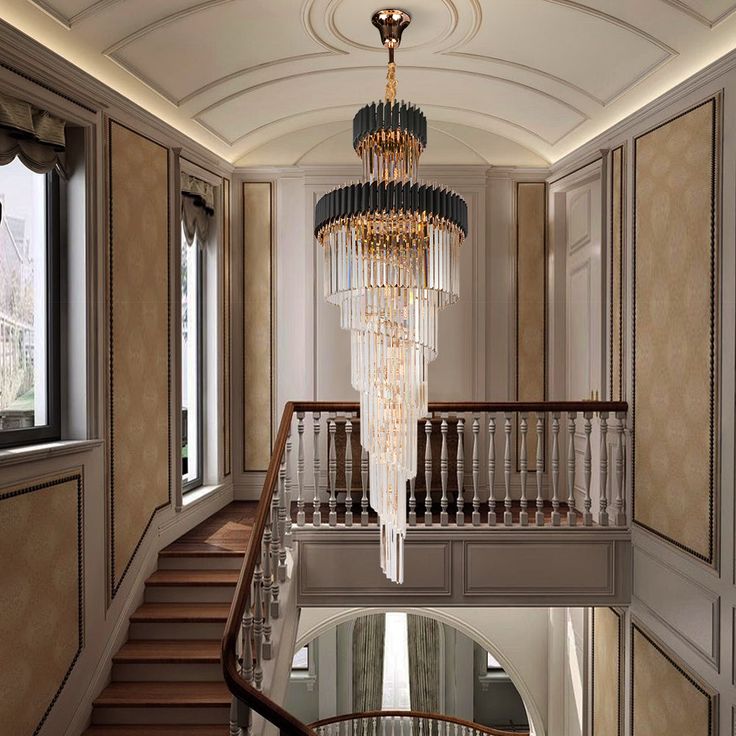 a chandelier hanging from the ceiling in a hallway with stairs leading up to it