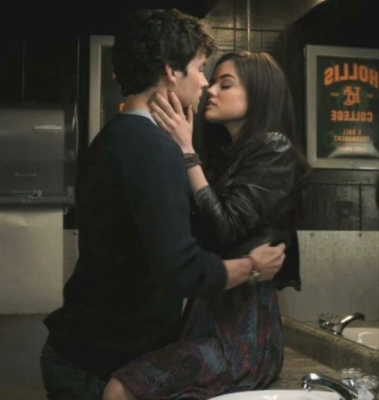 a man and woman kissing in front of a sink with the caption, i love you