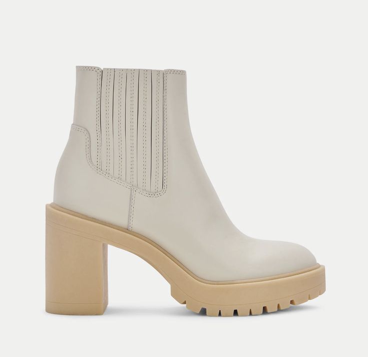 a woman's white boot with wooden heel and chunky soles on the side