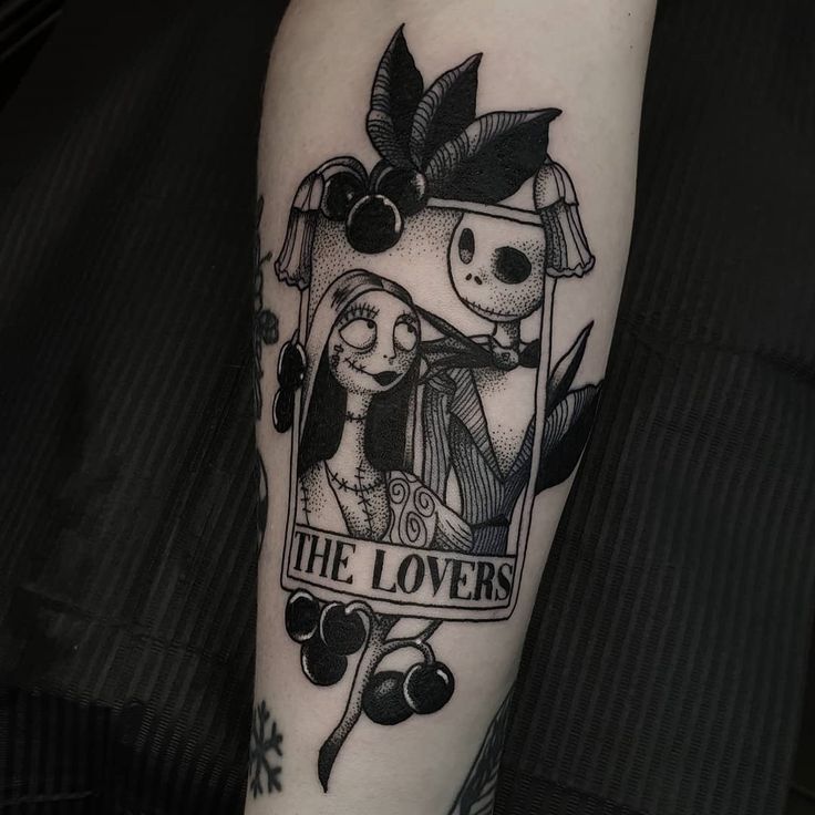 a person with a black and white tattoo on their arm that says, the lovers