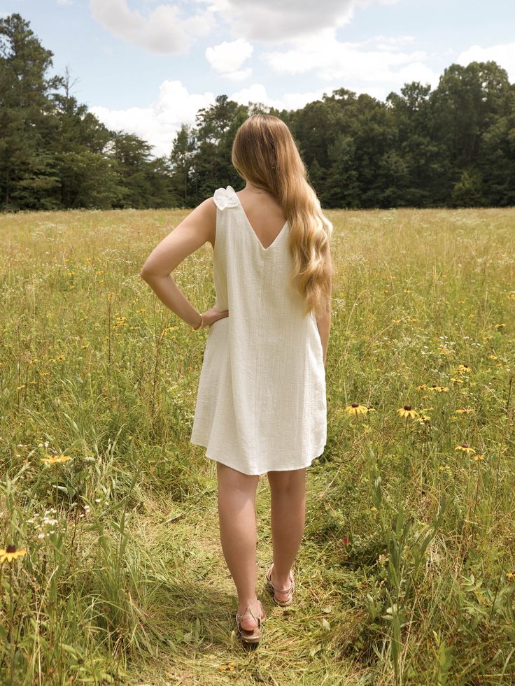 This is a white sleeveless v neck dress with a ruffle detail on the shoulder. The model is wearing a size small Sleeveless V Neck Dress, White Sleeveless, The Model, V Neck Dress, Graduation Dress, Clothes For Sale, Neck Dress, Dress Outfits, White Dress