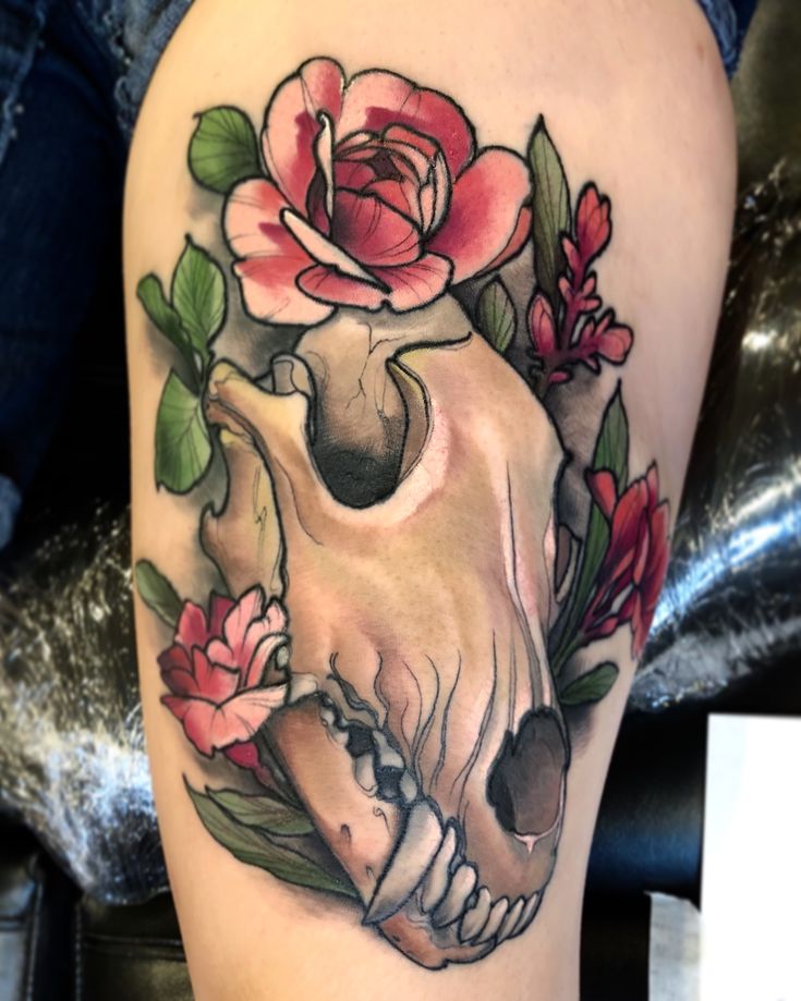 a tattoo with a skull and flowers on it