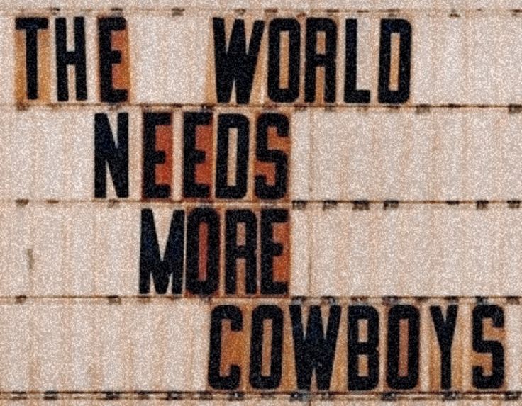 the words on the side of a building say, the world needs more cowboys