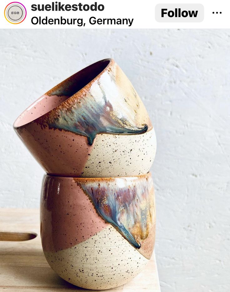 two ceramic bowls sitting on top of a wooden table