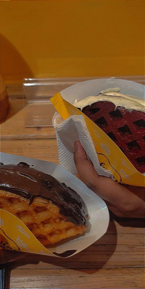 two plates with waffles and fruit on them, one being eaten by the other