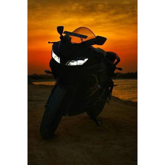 a motorcycle parked on the beach at sunset