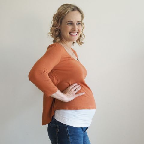 a pregnant woman standing with her hands on her hips