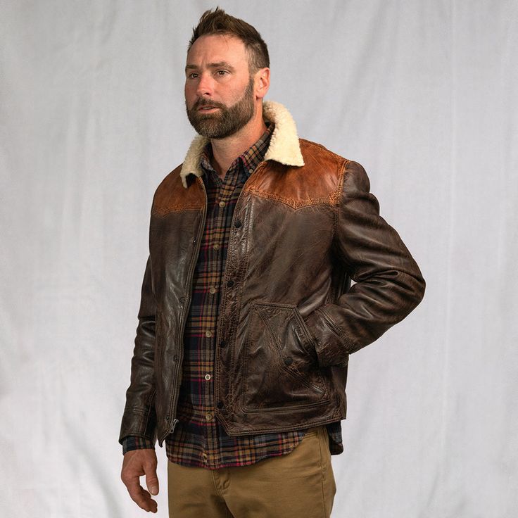 It takes a bold and capable design to bear our name, which is precisely what you’ll find in the Jackson Leather Sherpa Jacket. True to our brand and story, the Jackson showcases quality craftsmanship blended with a rugged vintage appeal through each and every stitch. This leather jacket runs true to size, but check the sizing guide to be sure. The classic two-tone Western yoke exterior was inspired by the high mountain valleys of the Bison State and features 100% full grain lambskin leather, sec Rugged Distressed Brown Outerwear For Fall, Rugged Leather Jacket For Winter, Rugged Fall Outerwear With Padded Collar, Rugged Brown Sport Coat For Winter, Classic Winter Outerwear With Contrast Stitching, Vintage Outerwear With Contrast Stitching For Winter, Rugged Distressed Brown Outerwear For Winter, Vintage Outerwear With Contrast Stitching For Fall, Classic Winter Outerwear With Selvedge Detail