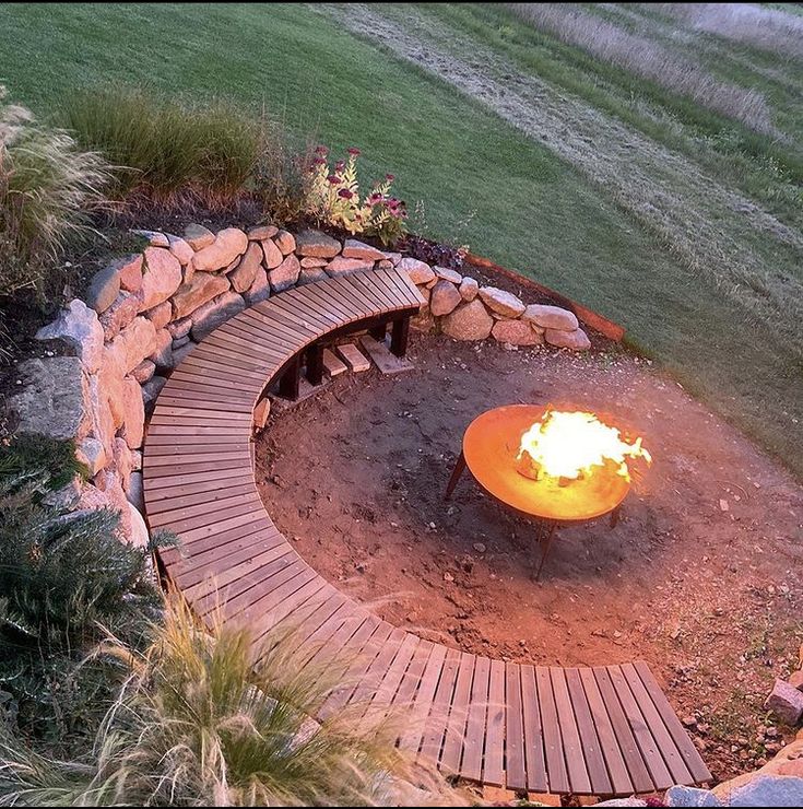 an outdoor fire pit surrounded by rocks and wood