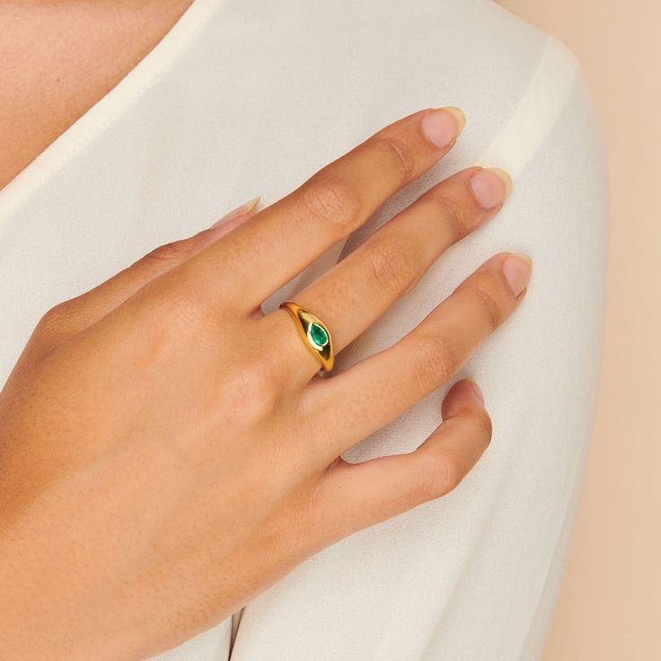 A gorgeous design, this cocktail ring is boldly unexpected. Stunning in its simplicity, the ring features an inlay pear-shaped emerald beautifully set in a gold band that packs a punch. Band is made of 14k gold over sterling silver. Hypoallergenic, nickel and lead free Tarnish resistant H2O sensitive. Before showering or working out, remove your plated jewelry. Clean your piece by buffing gently with a dry cloth and store it in your pouch. Gold Teardrop Emerald Ring, Gold Teardrop Emerald Promise Ring, Yellow Gold Teardrop May Birthstone Ring, Yellow Gold Teardrop Ring For May Birthstone, Modern Emerald Ring For Anniversary, Modern Emerald Anniversary Ring, Pear-shaped Gold Emerald Ring, Classic Teardrop Emerald Ring As Gift, Modern Open Emerald Ring With Birthstone