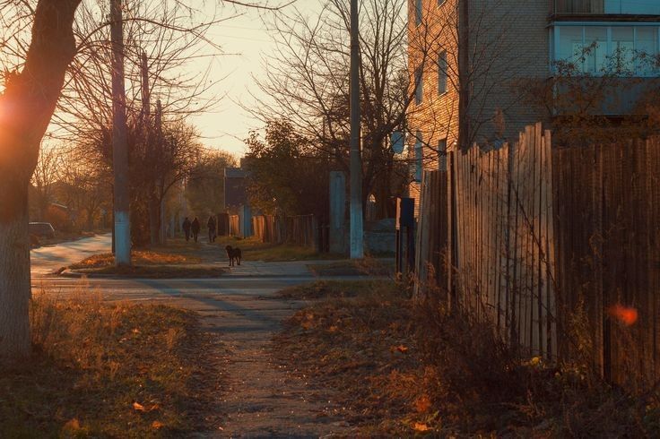 a person walking down a street at sunset