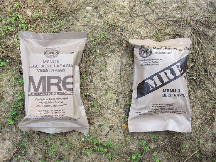 two bags of mrf are laying on the ground next to some grass and weeds