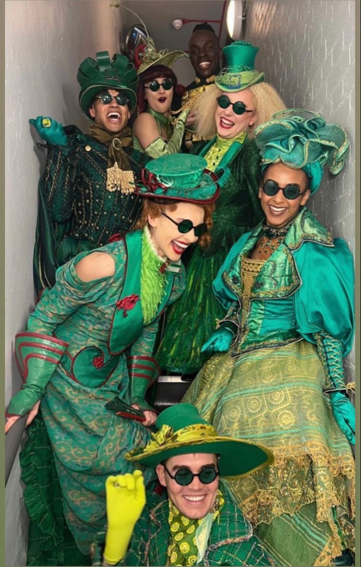 a group of people dressed in costume posing for a photo with hats and sunglasses on