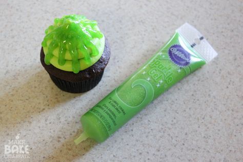 a tube of toothpaste next to a chocolate cupcake with green icing