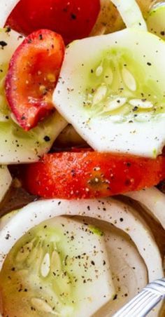 a salad with tomatoes, cucumbers and other toppings is shown in a bowl