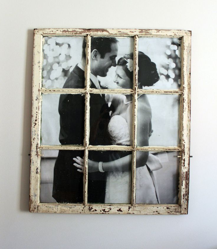 an old window frame with a couple kissing in front of it and some pictures on the wall