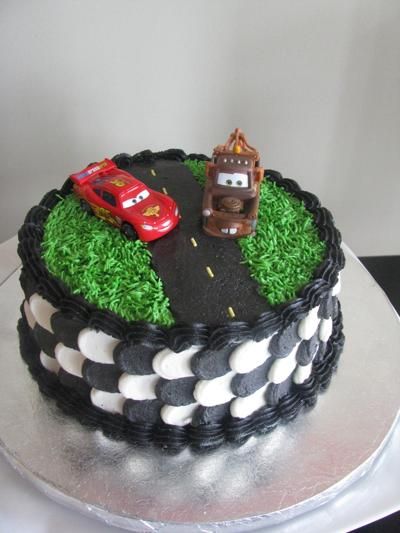 a birthday cake with cars and grass on top