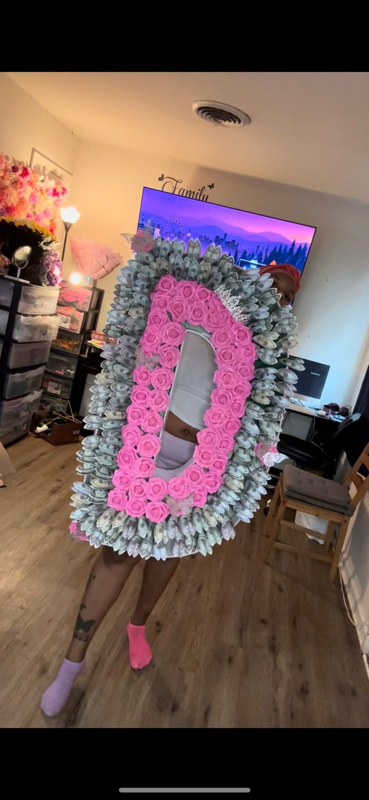 a woman holding up a large letter made out of flowers