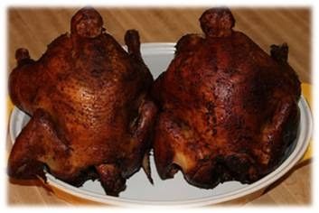 two pieces of meat sitting on top of a white plate in front of a wooden table