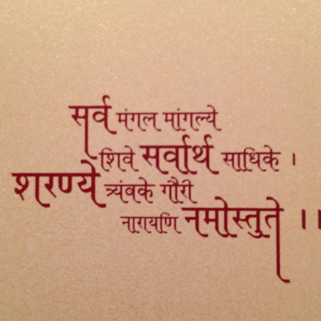 the words are written in two languages on a white surface with red lettering and black ink