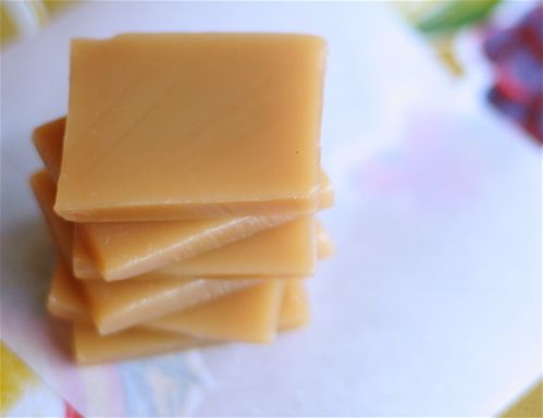 four pieces of soap sitting on top of each other in front of a flowered table cloth