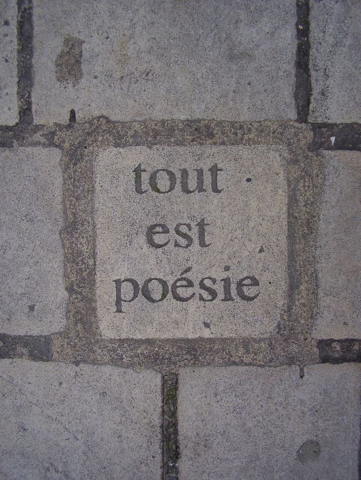 a sign that is on the side of a brick wall saying tour est posie