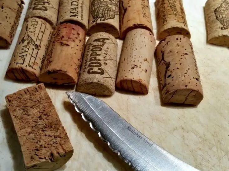 wine corks and a knife on a cutting board next to each other with words written on them