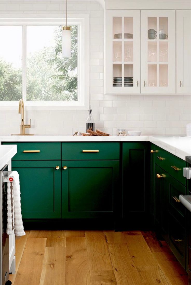 a kitchen with dark green cabinets and white counter tops is pictured in this image from the front view