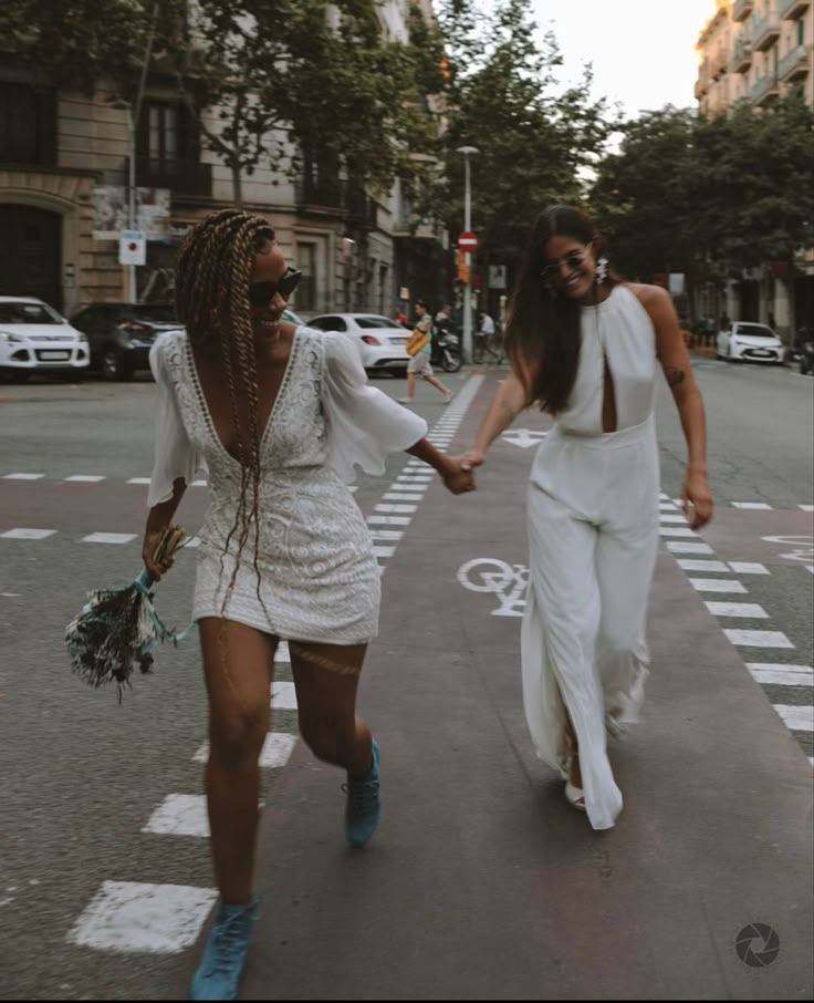 two women walking down the street holding hands