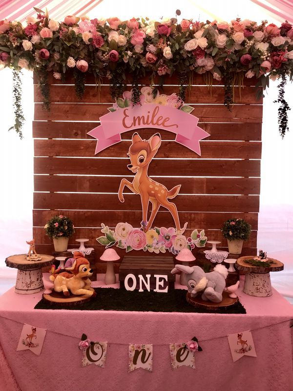 a pink table topped with stuffed animals under a wooden sign that says'emelie one '