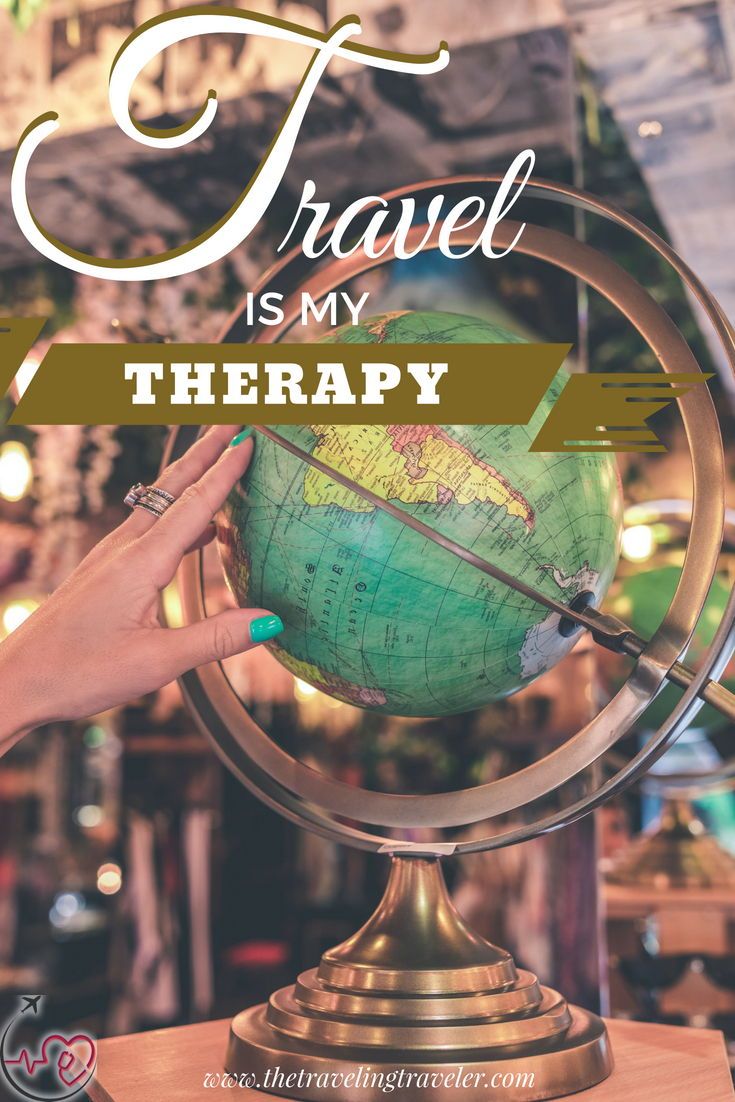 a globe with the words travel is my therapy on it and a hand pointing at it