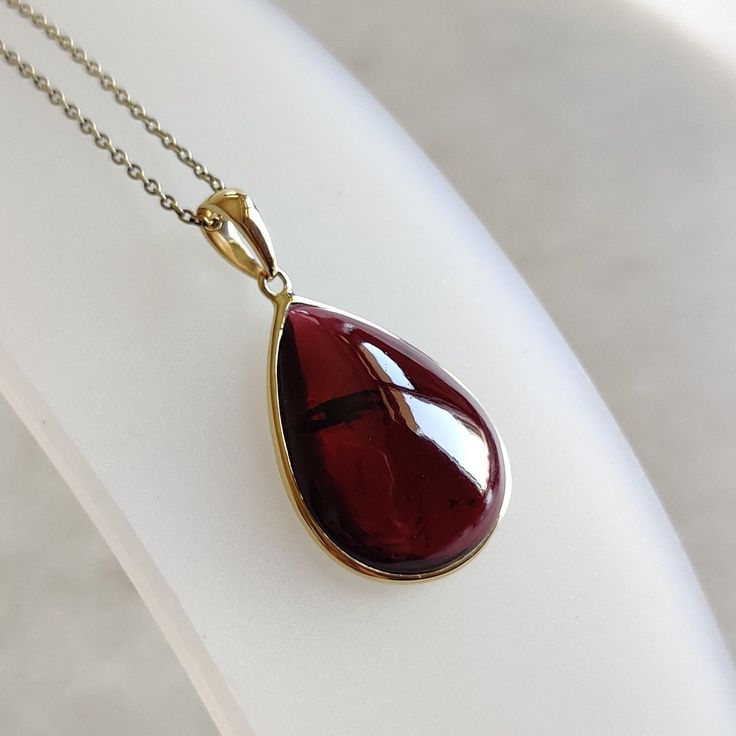 ITEM DESCRIPTION: >> The Pendant is made from Solid 14K Yellow Gold. Gemstone used is absolutely natural and ethically sourced. >> Natural Garnet in cabochon cut and pear shape with bezel setting is studded on it with utmost precision.  >> This is a minimalist design and is absolutely hassle-free and everyday jewelry.  Gem: Garnet Gem size: 15x20 mm pear Gem weight: 15.54 carats Gold purity: 14K (58.33% approx.) Gold weight: 0.57 grams  Gross weight: 3.68 grams The Gold purity is guaranteed and it comes with authentic 14K gold hallmark. Since this Pendant are handmade, It is Nickel/Lead FREE.  CUSTOMIZATION: --> You can choose your own gemstone. --> Kindly drop a message for the same. CUSTOMER SUPPORT: --> We are available 24/7 to respond to all your queries!  PACKAGING: --> The pendant co Cabochon Drop Jewelry For Gifts, Classic Polished Gemstones As A Gift, Classic Polished Gemstones For Gift, Classic Polished Gemstones For Gifts, Amber Garnet Jewelry As Gift, Amber Garnet Jewelry For Gift, Amber Garnet Jewelry Gift, Fine Garnet Necklace As Gift, Fine Jewelry Garnet Necklace As Gift