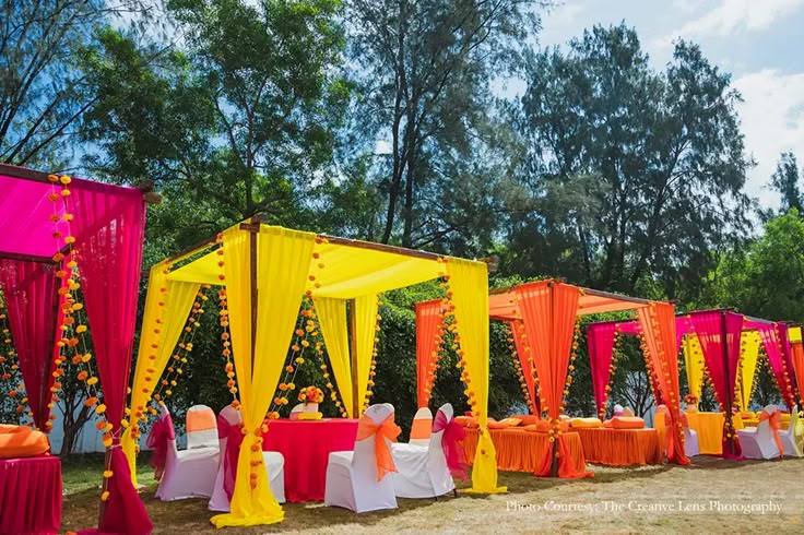 an outdoor wedding setup with orange and pink draping