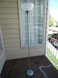 a floor lamp sitting on top of a wooden porch