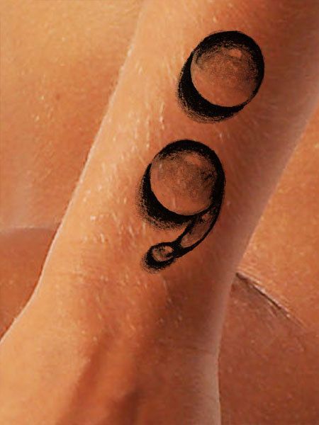 a woman's arm with black ink on it and two circles in the middle