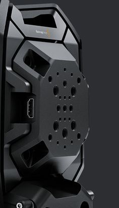 the back side of a black speaker on a dark background