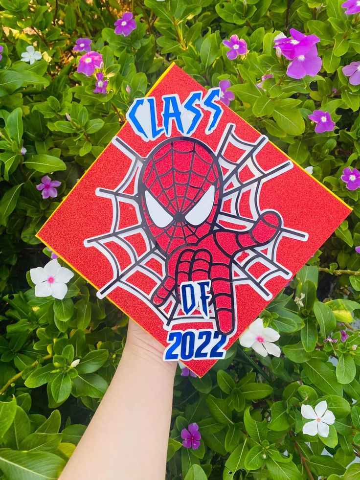 someone is holding up a graduation cap that says class of 202 in front of some flowers