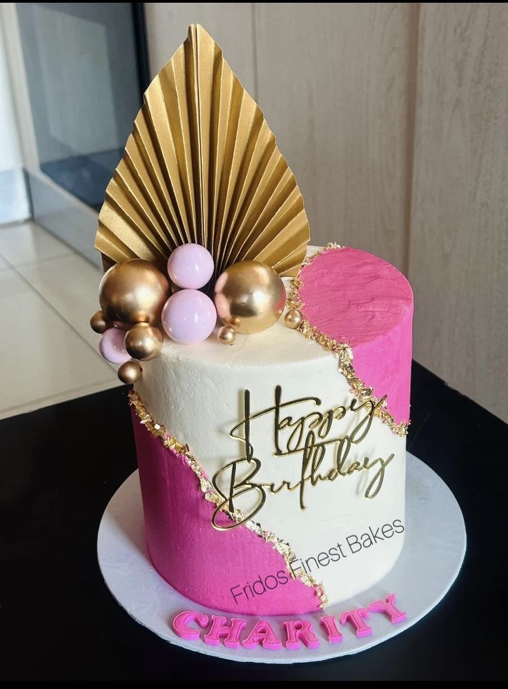 a birthday cake decorated with pink and gold decorations