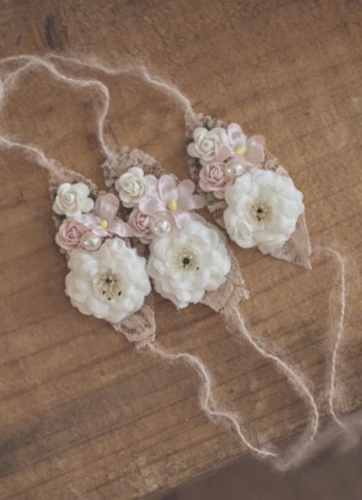 some flowers are sitting on top of a piece of wood and string wrapped in twine