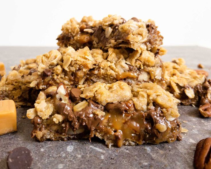 three cookies stacked on top of each other with pecans and chocolate chips around them