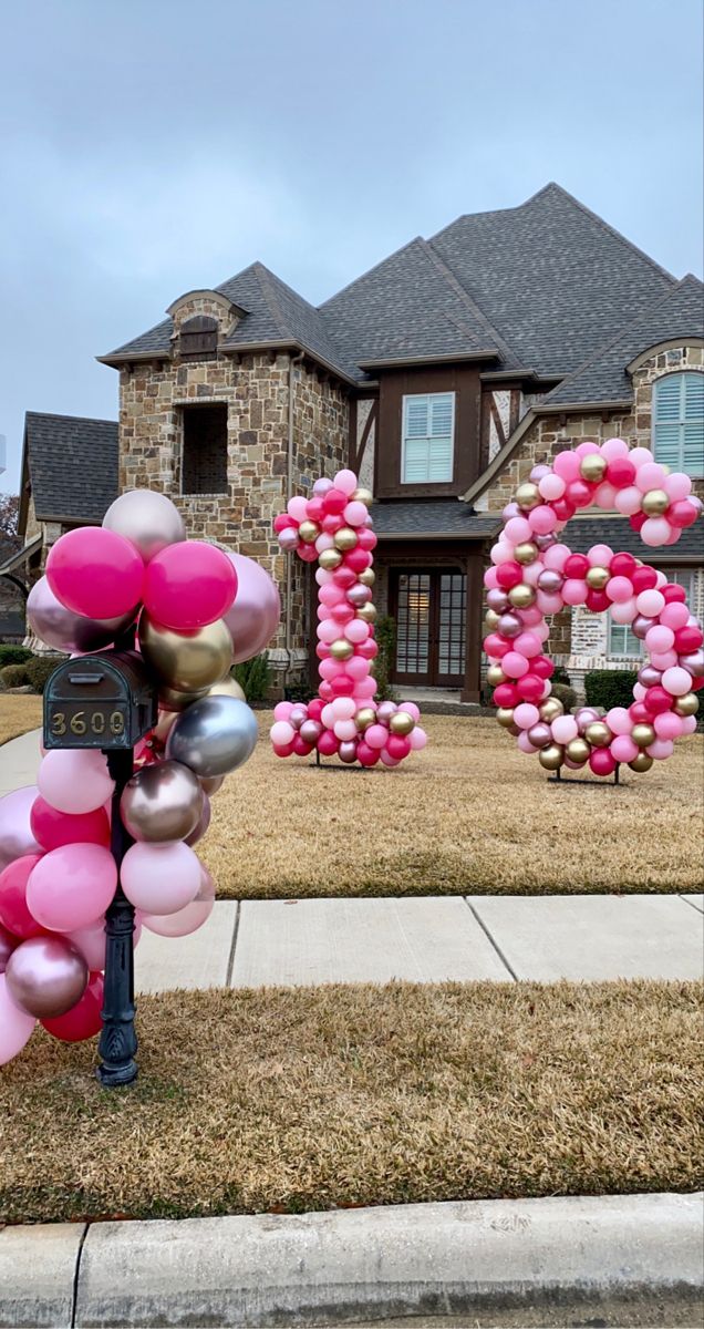 a house is decorated with balloons and the number 20 sits in front of it,