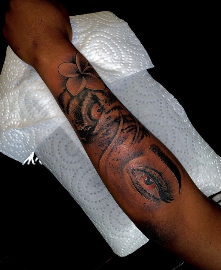 a person with a tattoo on their arm holding a white towel and looking at the camera