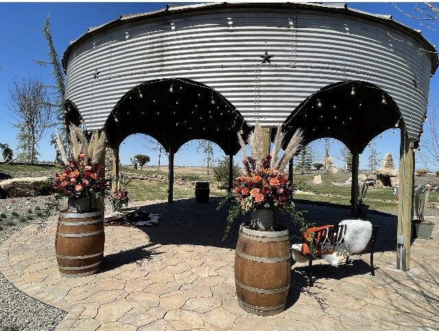 an outdoor area with several wooden barrels and flowers