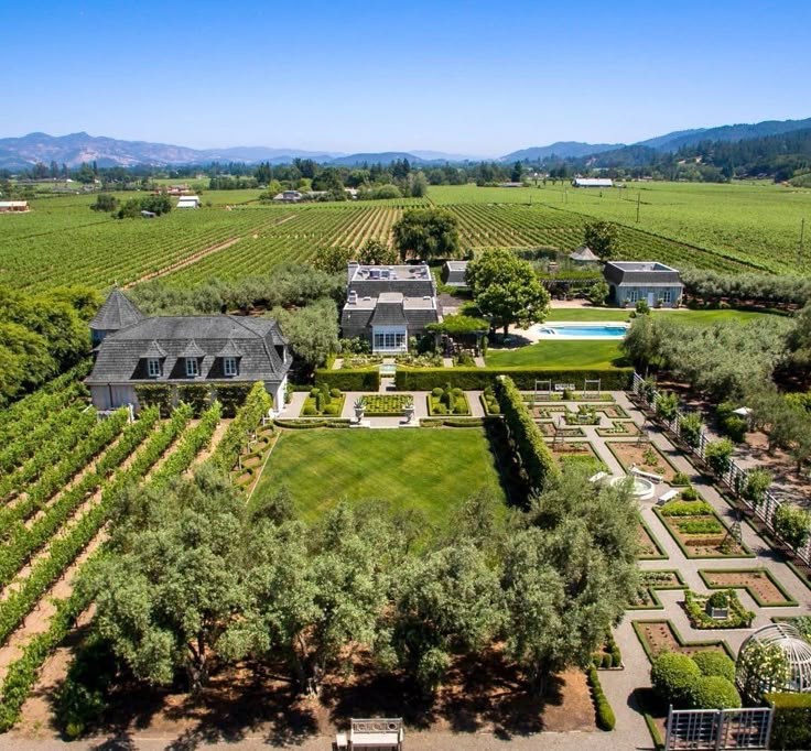 an aerial view of a large estate surrounded by trees and hedges in the middle of a field