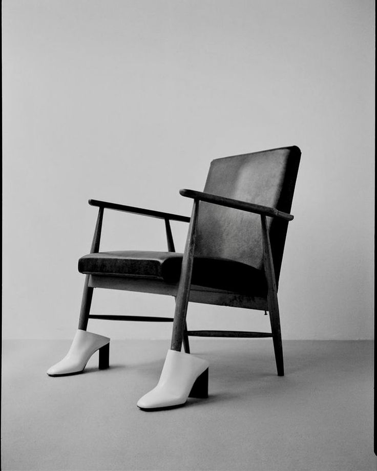 a black and white photo of a pair of shoes sitting on a chair