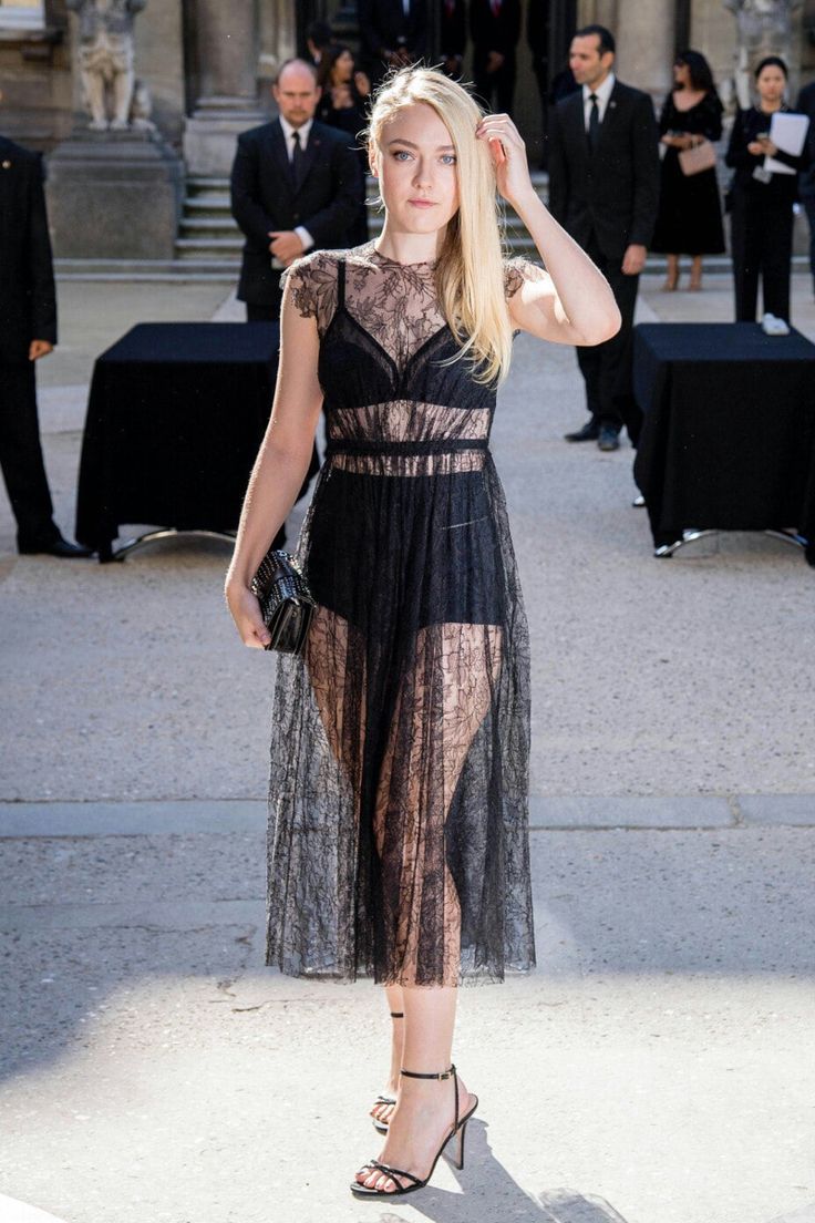 a woman in a black dress posing for the camera