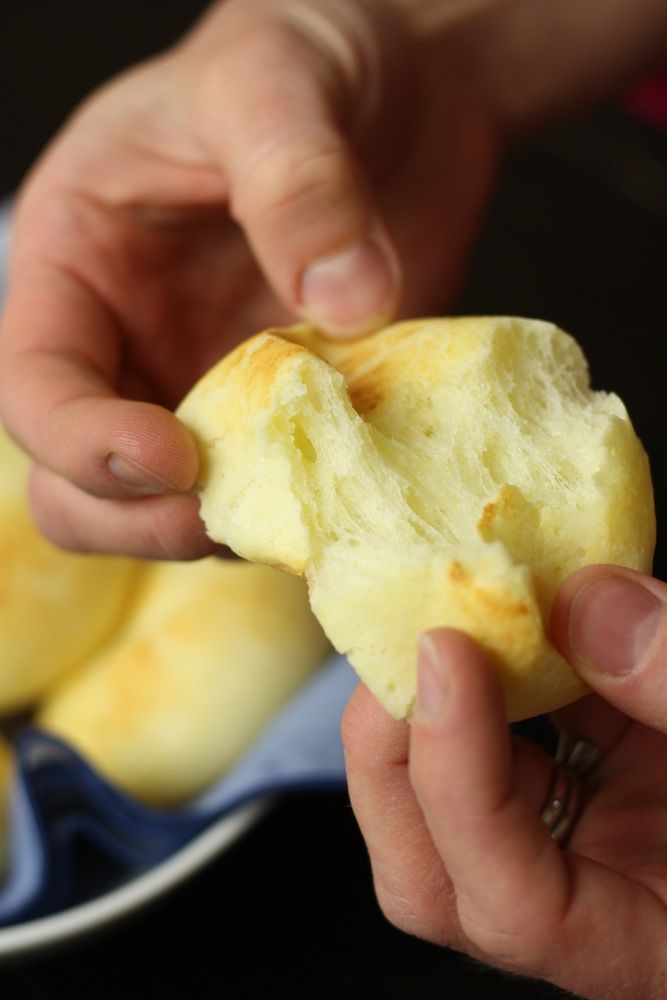 a person holding a piece of bread in their hand while they are about to eat it