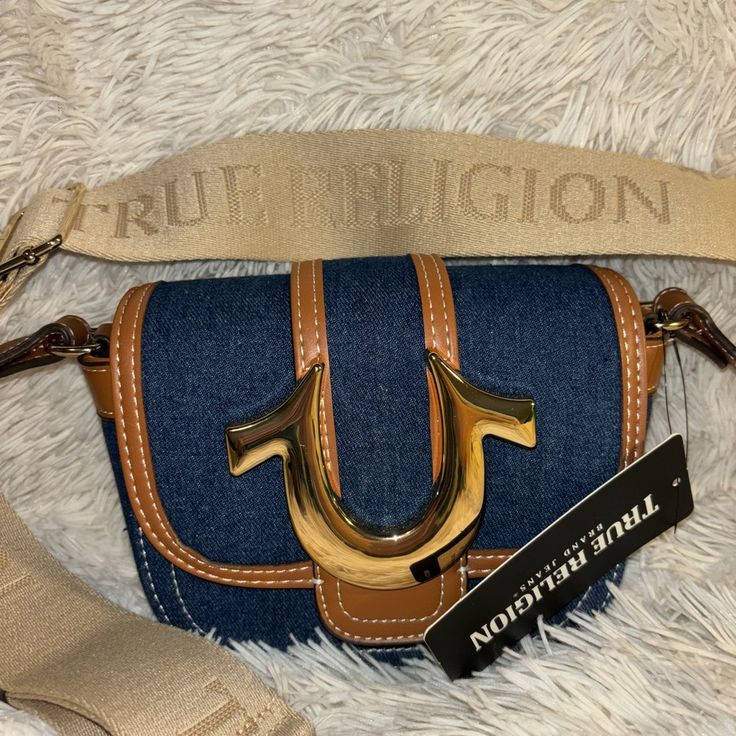 True Religion Bag Brand New Trendy Brown Shoulder Bag With Branded Hardware, Trendy Brown Bag With Branded Hardware, Trendy Brown Satchel With Branded Hardware, Casual Crossbody Bag With Gold-tone Hardware, Casual Satchel With Gold-tone Hardware, Casual Shoulder Bag With Branded Hardware For On-the-go, Casual Leather Bags With Branded Hardware, Blue Casual Bag With Branded Hardware, Casual Blue Bag With Branded Hardware