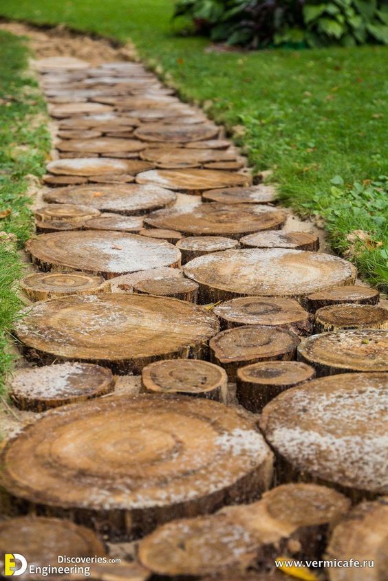 a path made out of logs in the grass